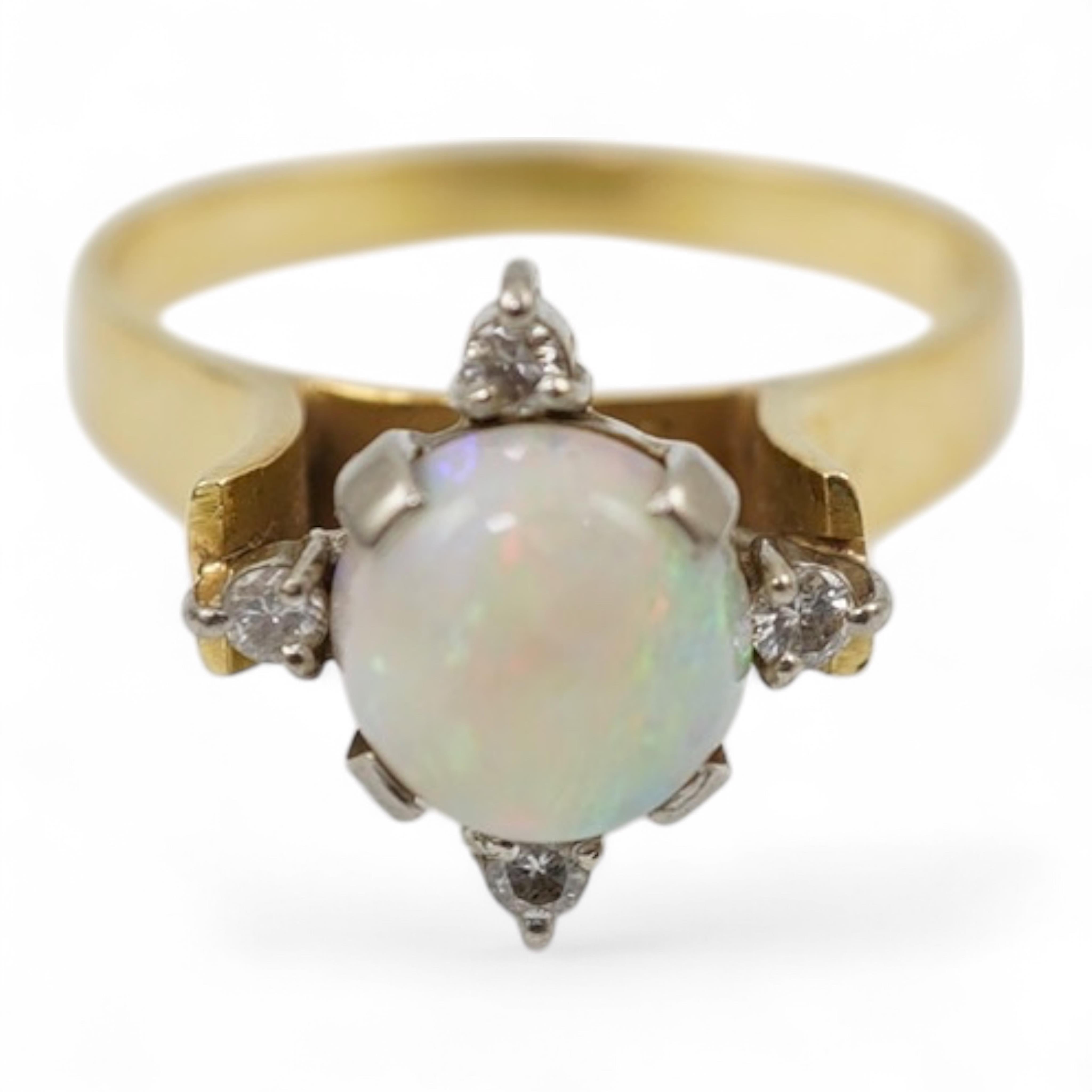 A yellow metal (stamped 18), single stone white opal and four stone diamond chip set ring, size P/Q, gross weight 3.8 grams.